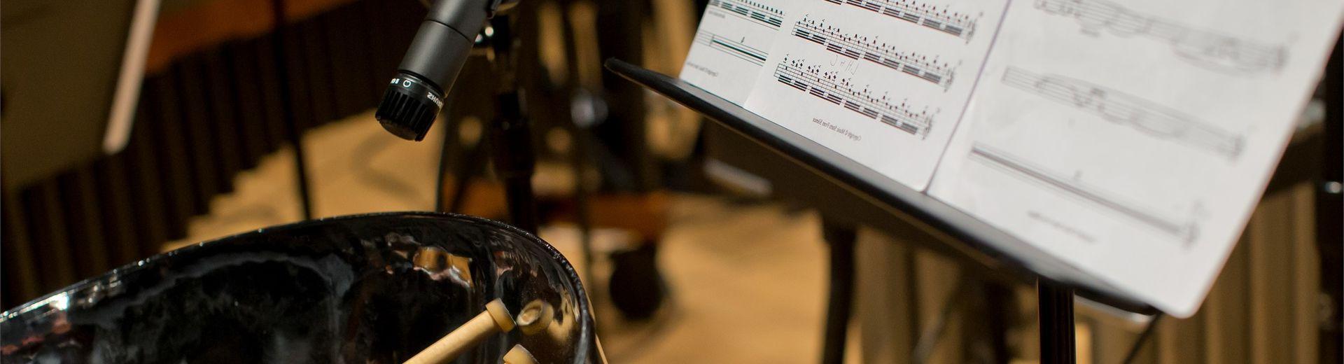 Student playing and recording the drums with sheet music